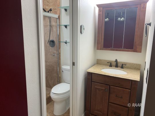 1004 South Farragut Street Ridgecrest, CA 93555 - Photo 13 of 13 a bathroom with a toilet a sink and shower