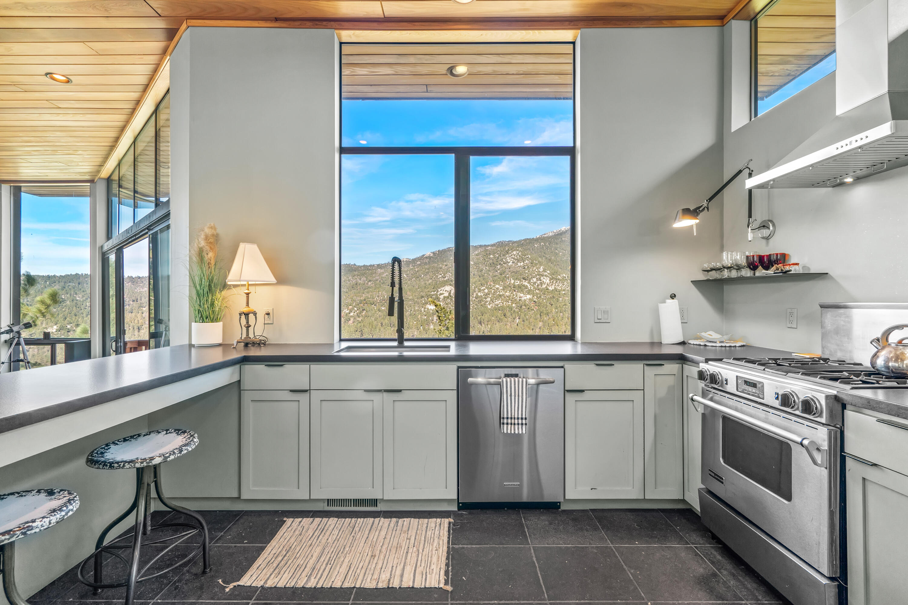 54685 Crest Drive Idyllwild, CA 92549 - Photo 24 of 50 a kitchen with a sink stove and wooden cabinets