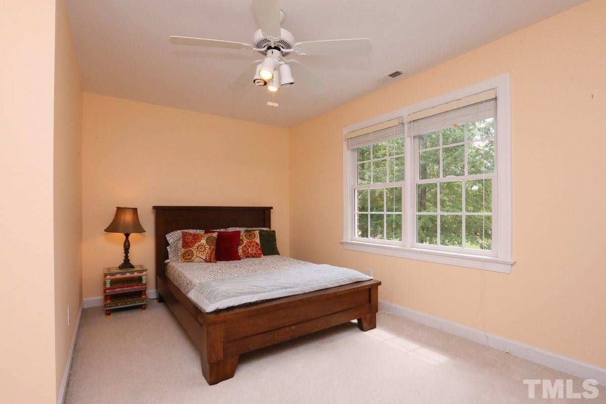 2621 Lizei Street Raleigh, NC 27616 - Photo 16 of 25 a bedroom with a bed lamp and a large window