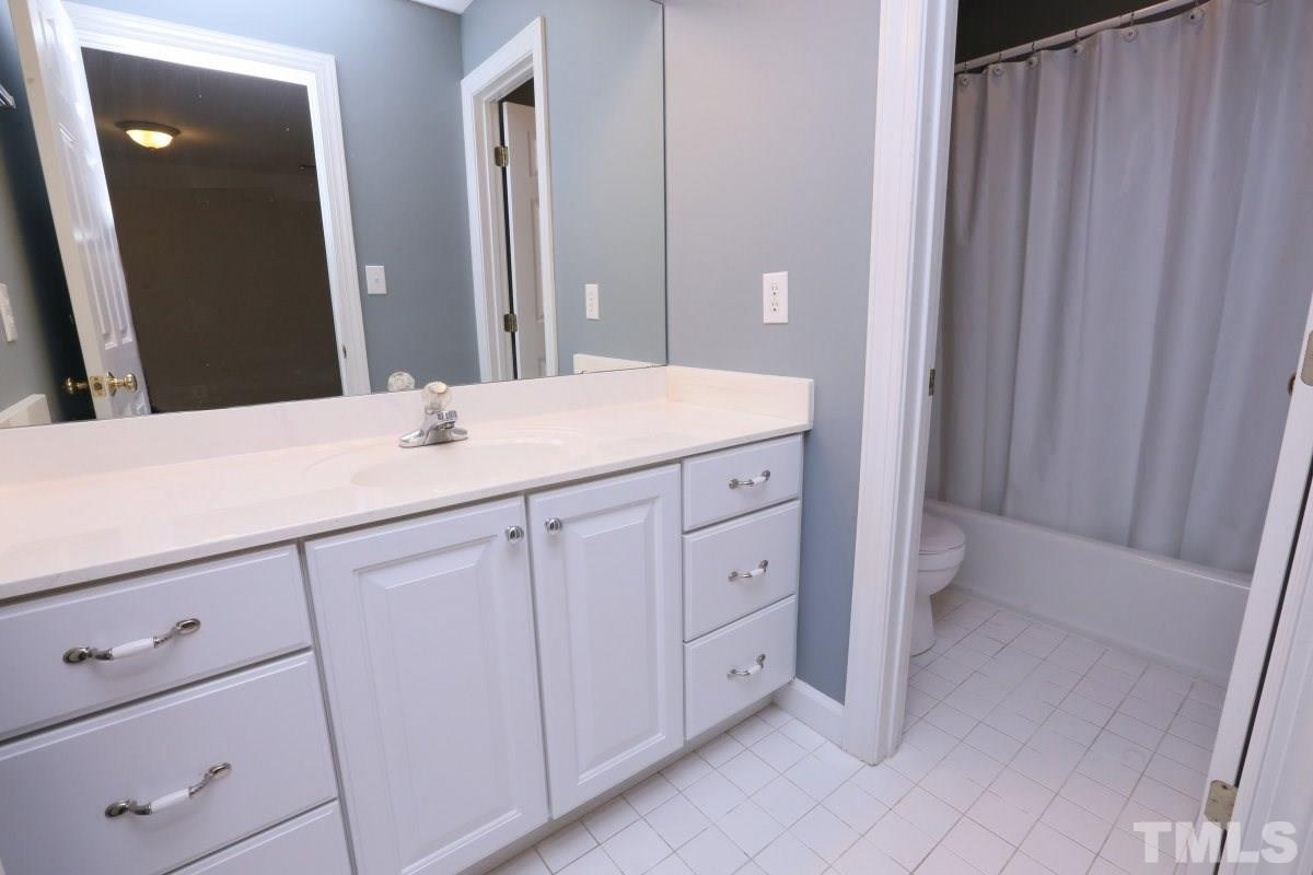 2621 Lizei Street Raleigh, NC 27616 - Photo 17 of 25 a bathroom with a sink and a mirror