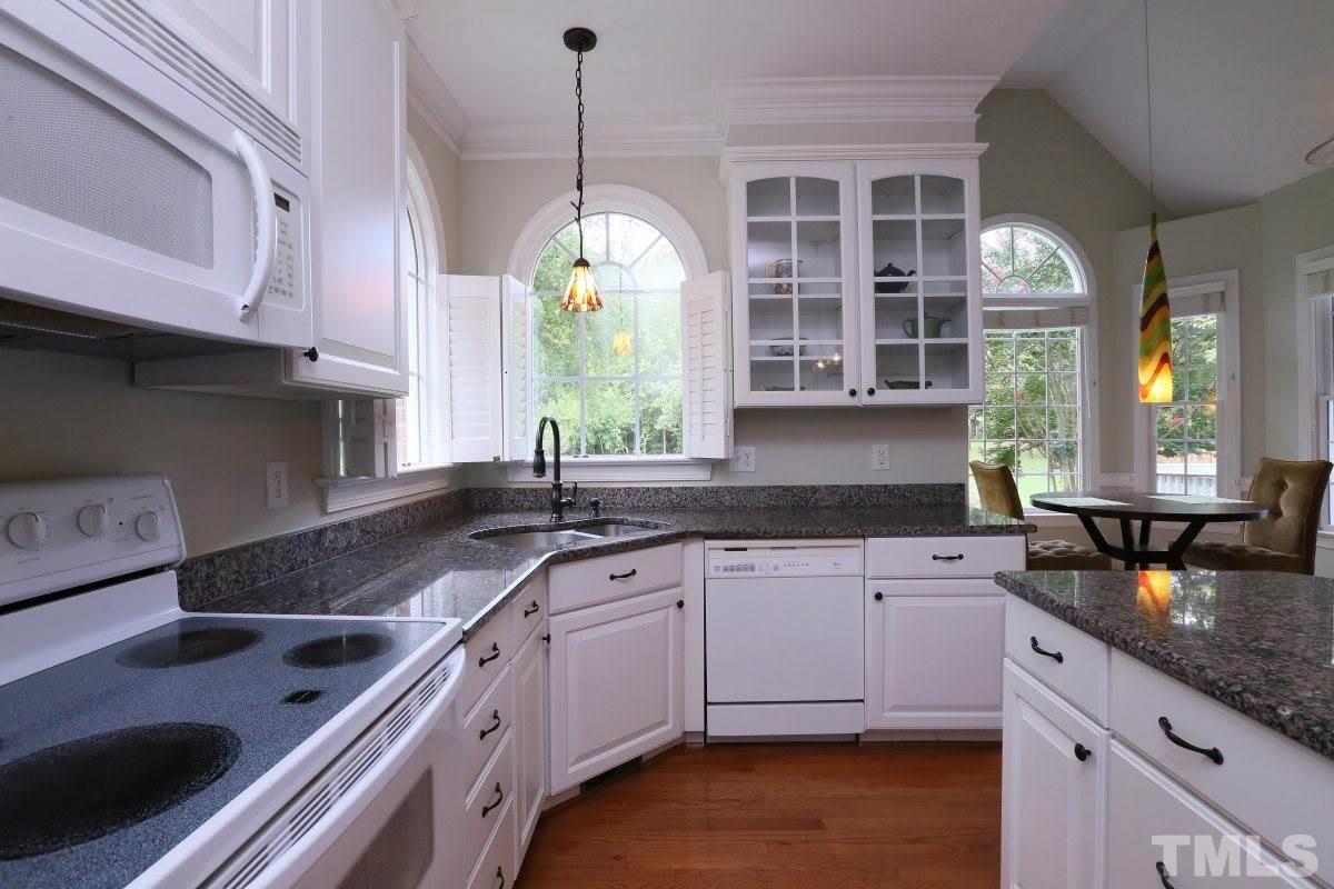 2621 Lizei Street Raleigh, NC 27616 - Photo 8 of 25 a kitchen with granite countertop stainless steel appliances a sink stove and cabinets