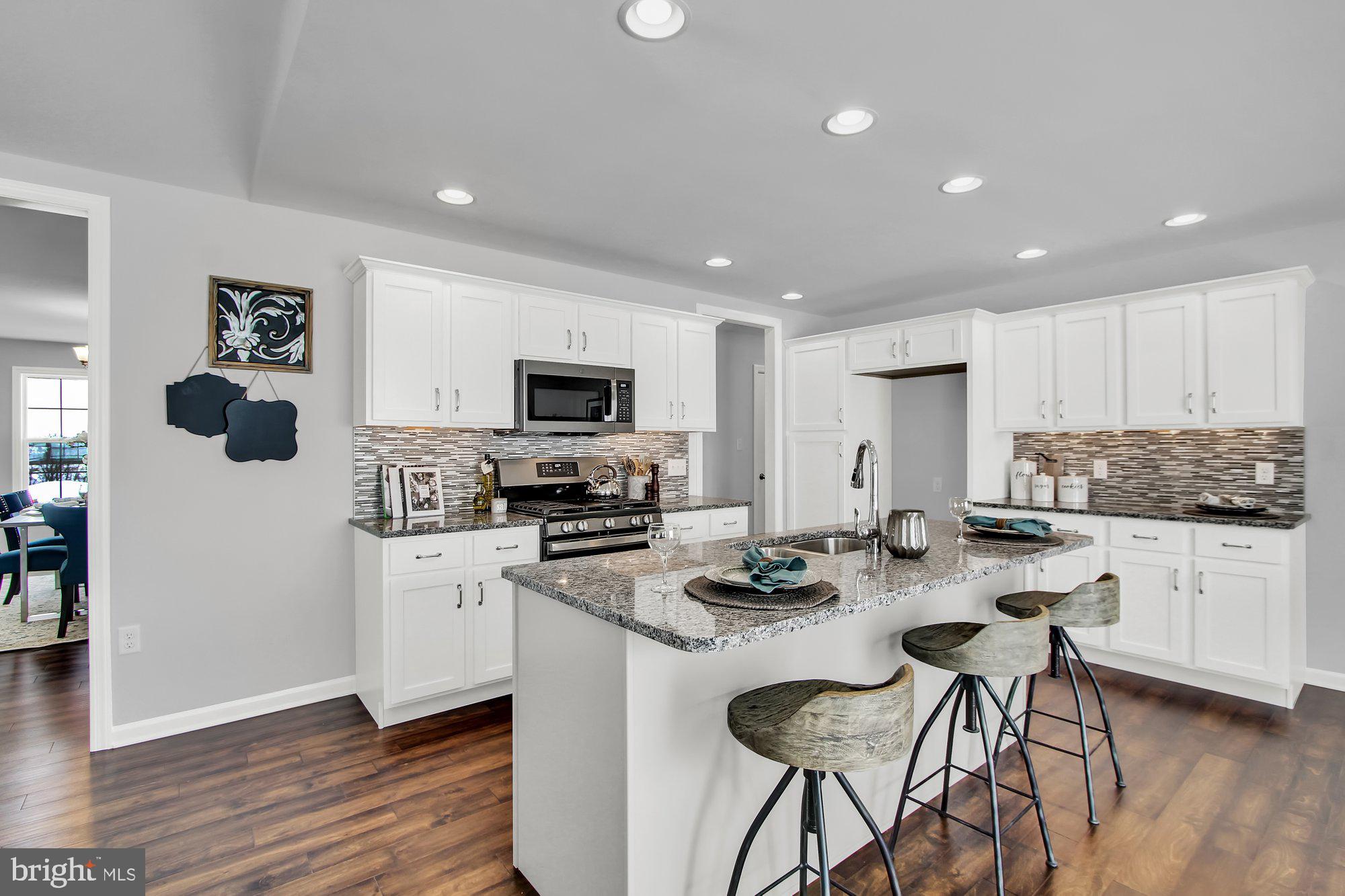 602 Rishel Drive York, PA 17406 - Photo 10 of 30 a kitchen with stainless steel appliances kitchen island granite countertop a stove a sink a refrigerator and white cabinets with wooden floor