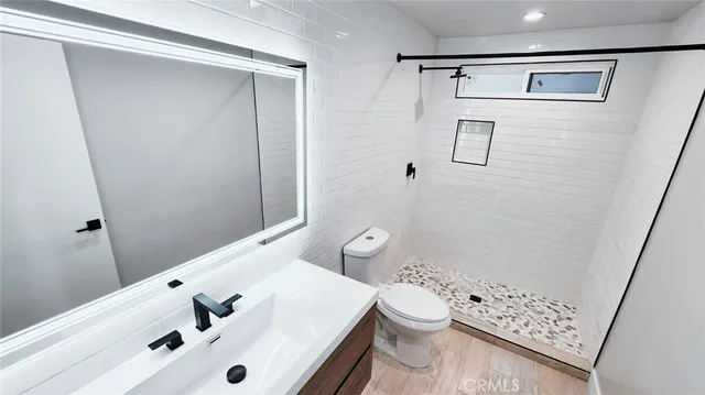 a bathroom with a sink a toilet and shower