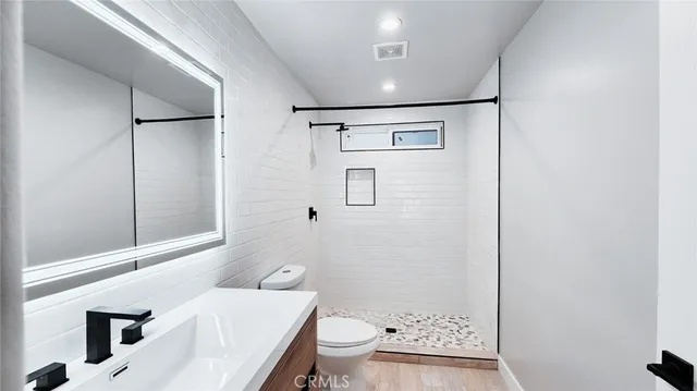 a bathroom with a sink a toilet and shower