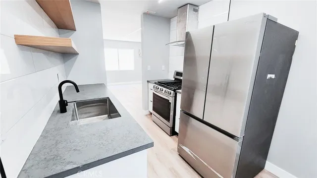 a kitchen with stainless steel appliances granite countertop a refrigerator and a sink