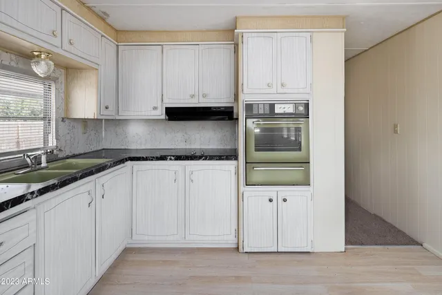 a kitchen with white cabinets and refrigerator