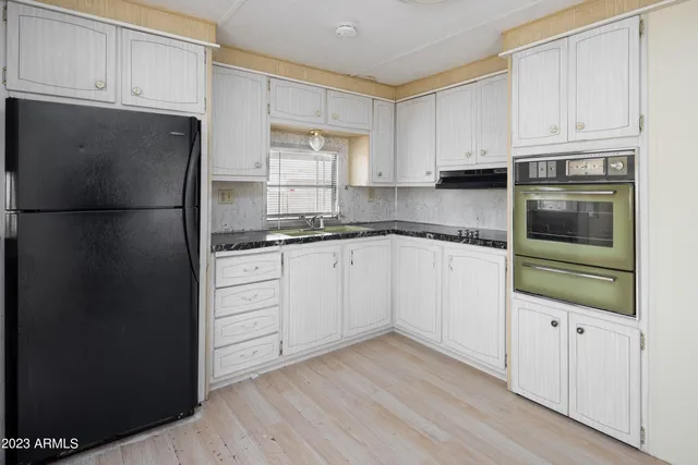 a kitchen with granite countertop white cabinets and stainless steel appliances