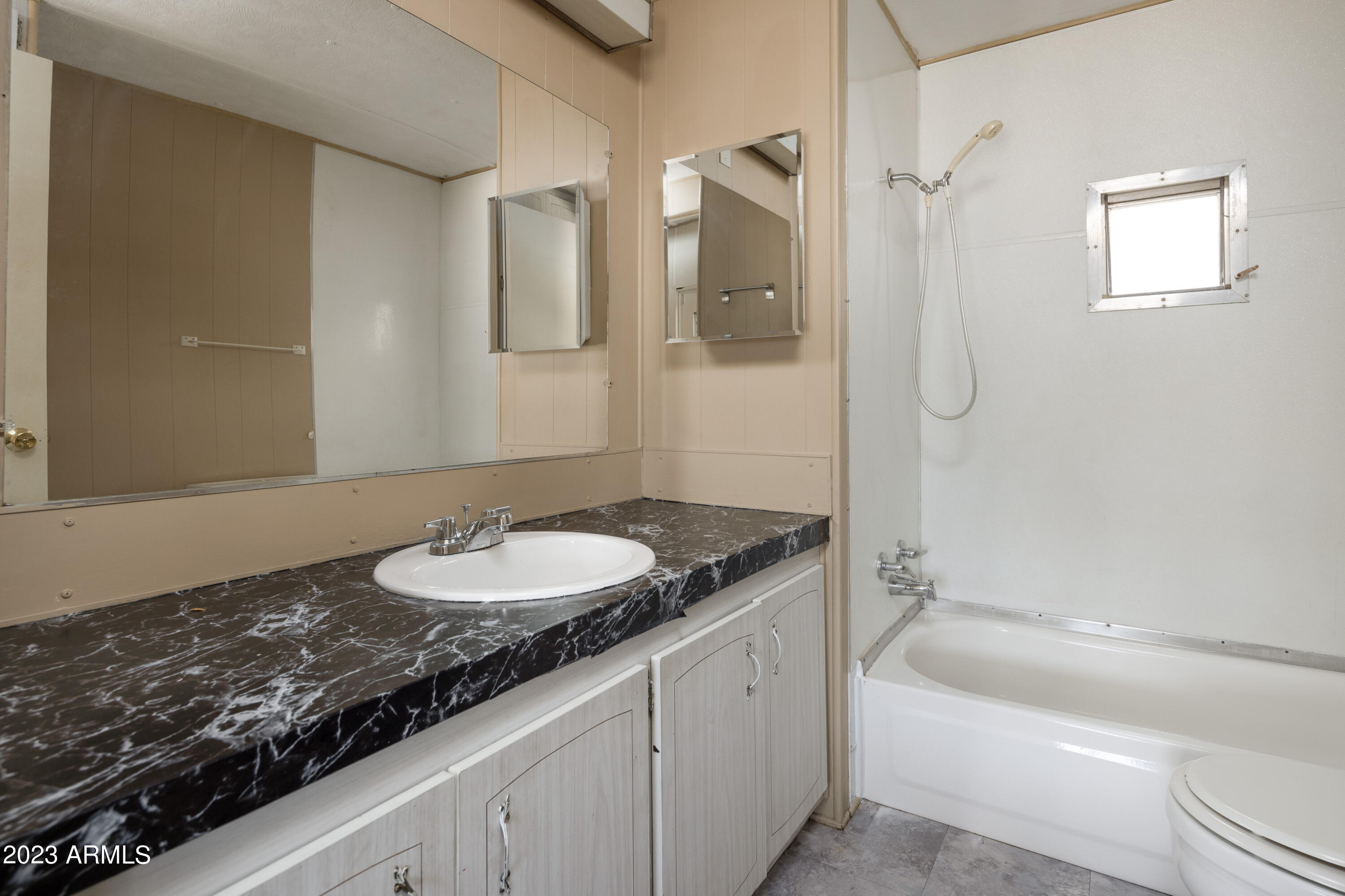 9618 East Aspen Circle Mesa, AZ 85208 - Photo 18 of 30 a bathroom with a granite countertop sink a mirror a bathtub and shower