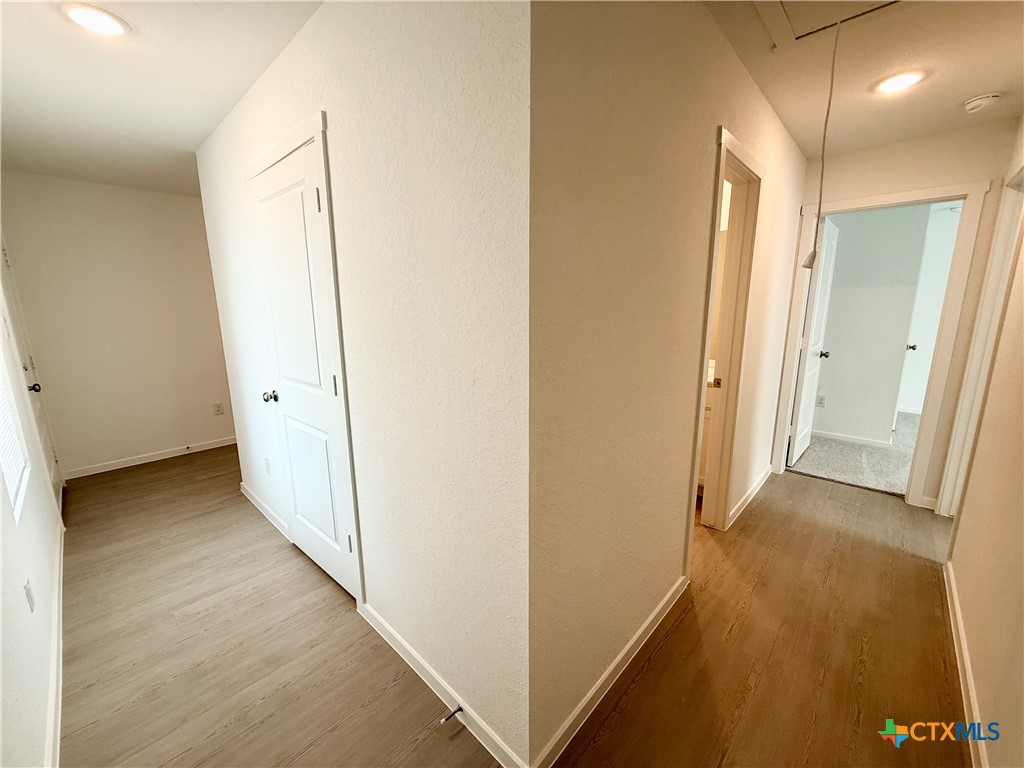 413 Moscato Road New Braunfels, TX 78130 - Photo 27 of 28 a view of a hallway with wooden floor