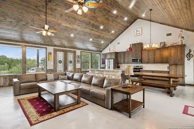 a living room with furniture a large window and a chandelier
