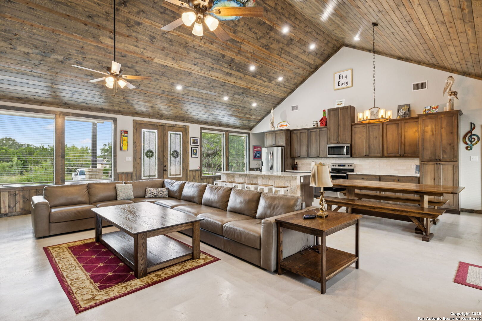 a living room with furniture a large window and a chandelier