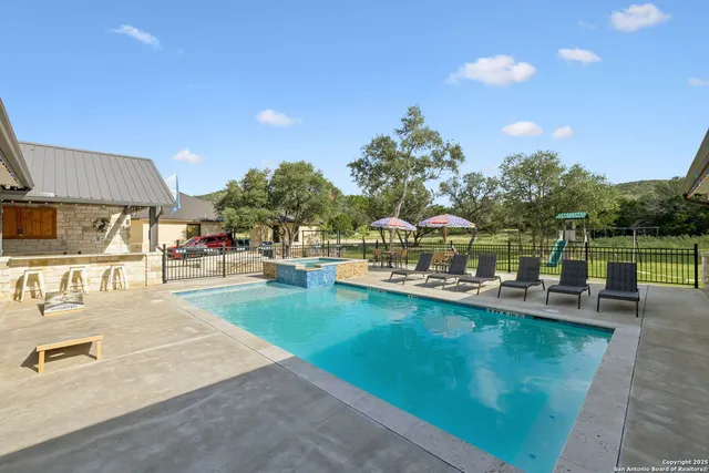 a view of a swimming pool with a patio and a yard