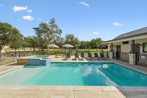 a view of swimming pool with a garden and patio