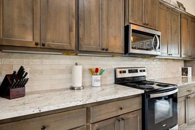 a kitchen with granite countertop cabinets and a stove top oven