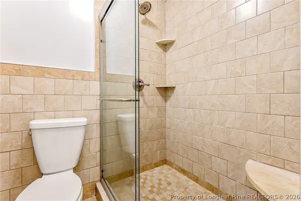 a bathroom with a toilet and a shower