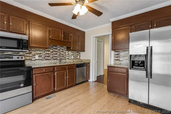a kitchen with stainless steel appliances granite countertop a refrigerator a oven a sink with island and cabinets