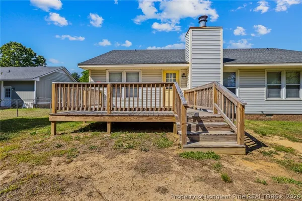 a view of a house with backyard and wooden fence