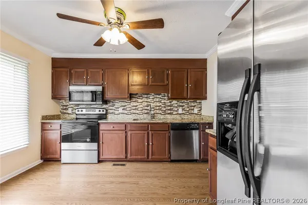 a kitchen with stainless steel appliances granite countertop a refrigerator and a stove top oven