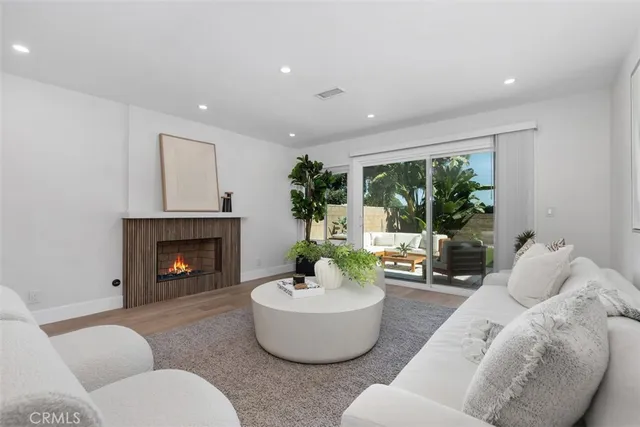 a kitchen with a refrigerator a stove a sink and a dining table with wooden floor