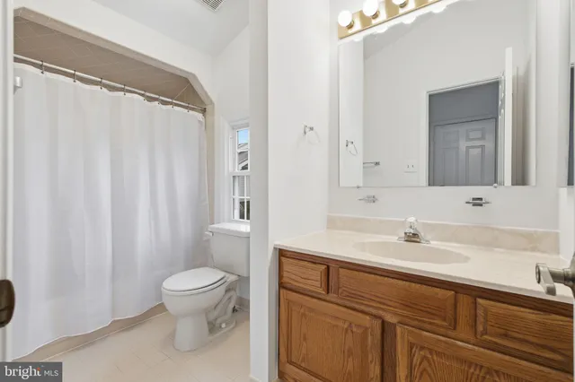 a bathroom with a sink a toilet and shower curtain