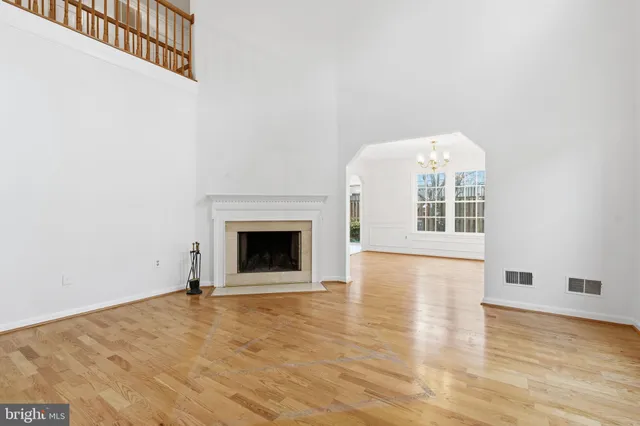 a view of empty room with wooden floor and fireplace