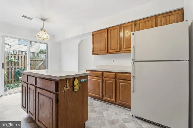 a kitchen with stainless steel appliances granite countertop a refrigerator a sink dishwasher a stove with wooden cabinets