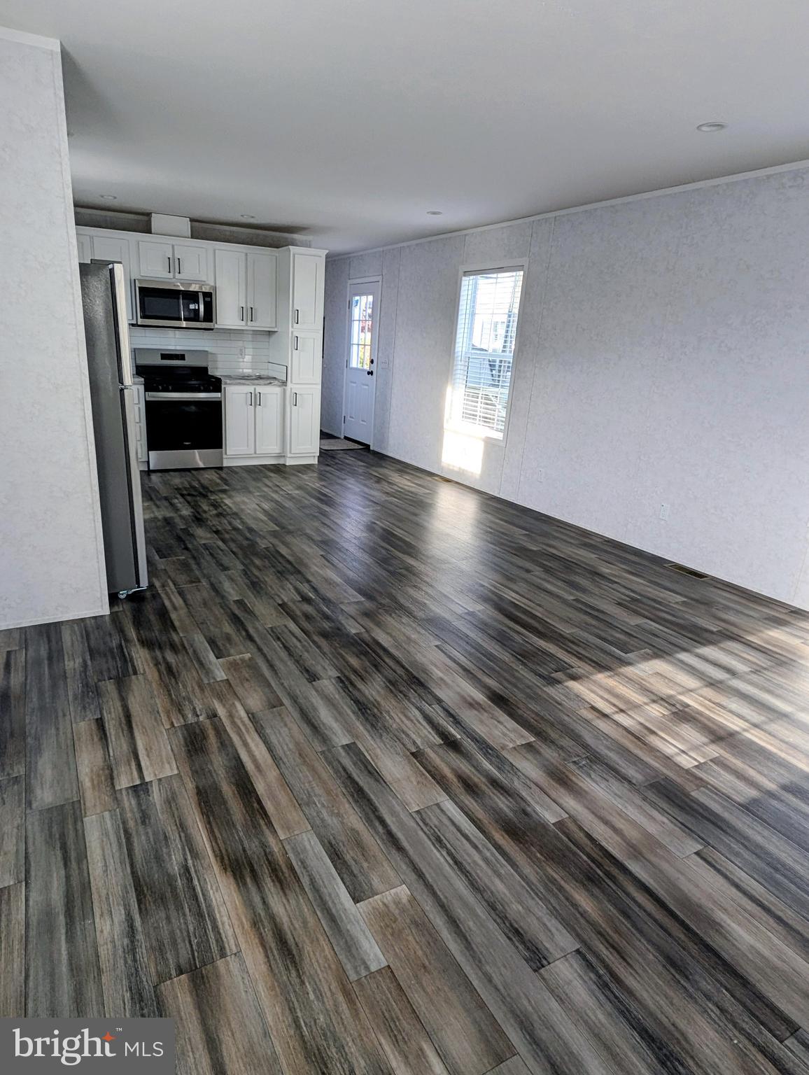 16 Abbey Road Coatesville, PA 19320 - Photo 3 of 8 a view of kitchen and empty room with wooden floor