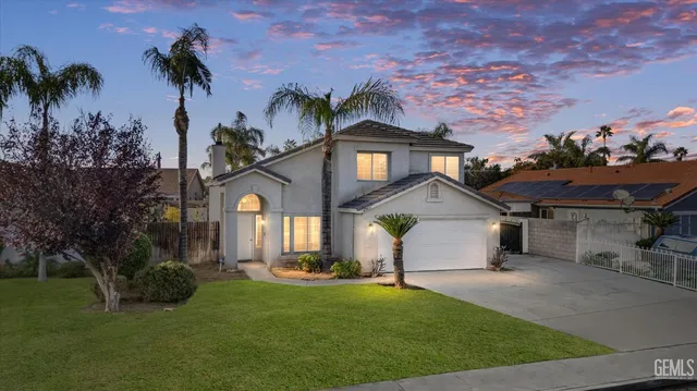 a front view of a house with a garden and yard