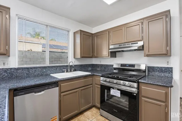 a view of an empty room with window and a ceiling fan