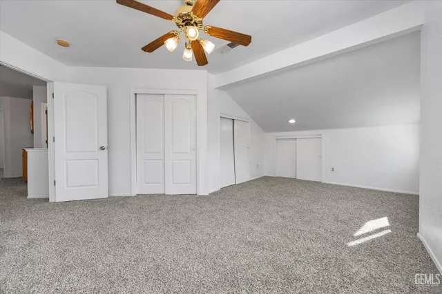 an empty room with closet and a ceiling fan