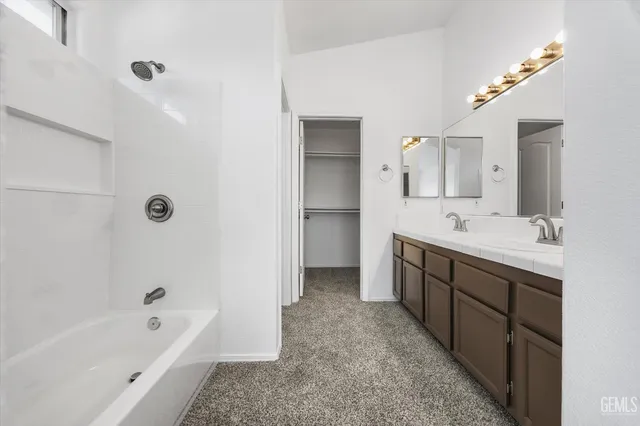 an empty room with chandelier fan and windows