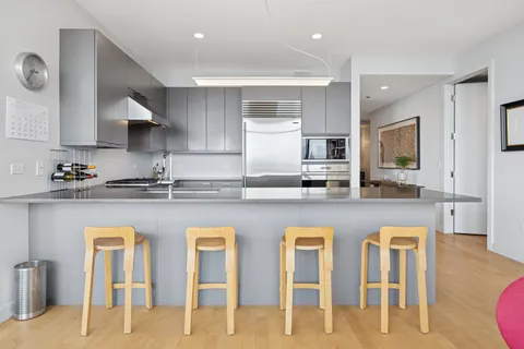 a kitchen with white cabinets and chairs