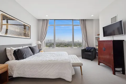 a bedroom with a bed and large window