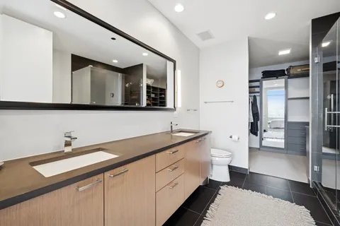 a spacious bathroom with a double vanity sink a mirror and a shower