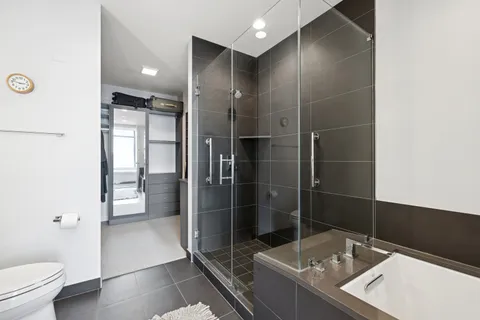 a bathroom with a granite countertop sink a toilet and shower