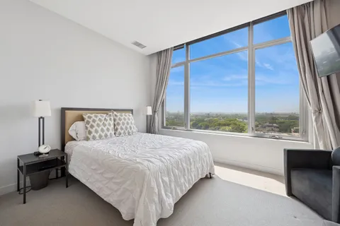 a bedroom with a bed and a large window