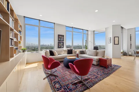 a living room with furniture large windows and a rug