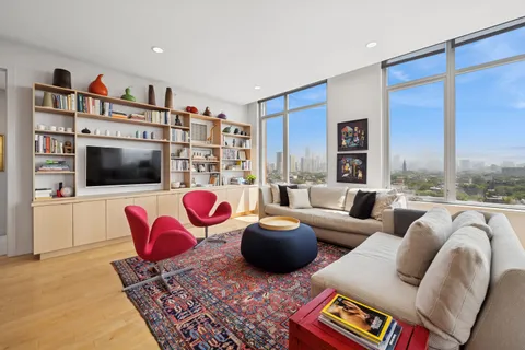 a living room with furniture a flat screen tv and a floor to ceiling window