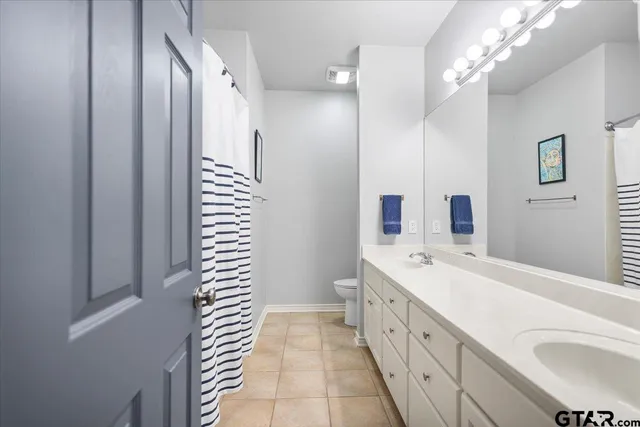 a spacious bathroom with a double vanity sink a large mirror and a shower
