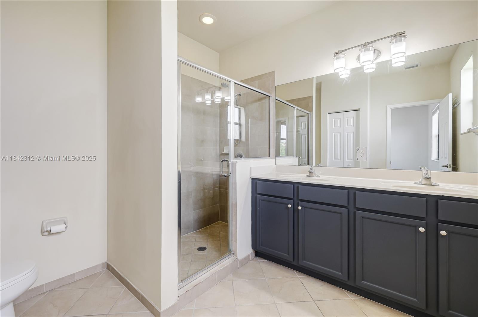 23634 Southwest 117 Place Homestead, FL 33032 - Photo 12 of 31 a bathroom with a shower sink and mirror