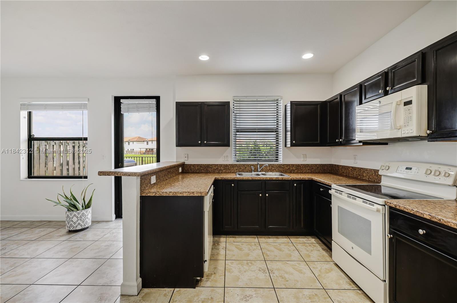 23634 Southwest 117 Place Homestead, FL 33032 - Photo 9 of 31 a kitchen with a sink a stove top oven and a counter top space