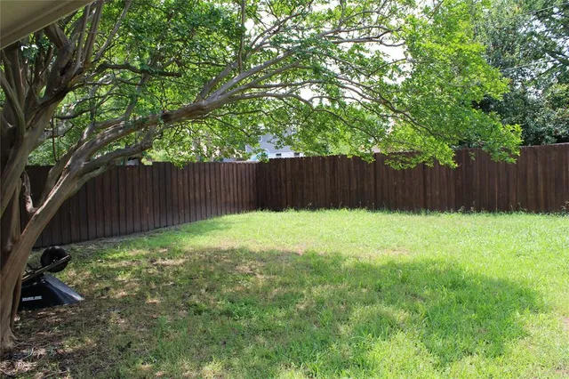 a view of garden with wooden fence