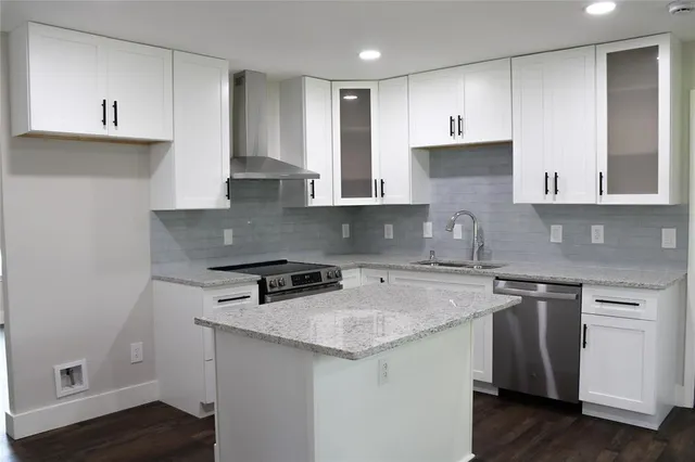 a kitchen with stainless steel appliances granite countertop a sink stove and cabinets