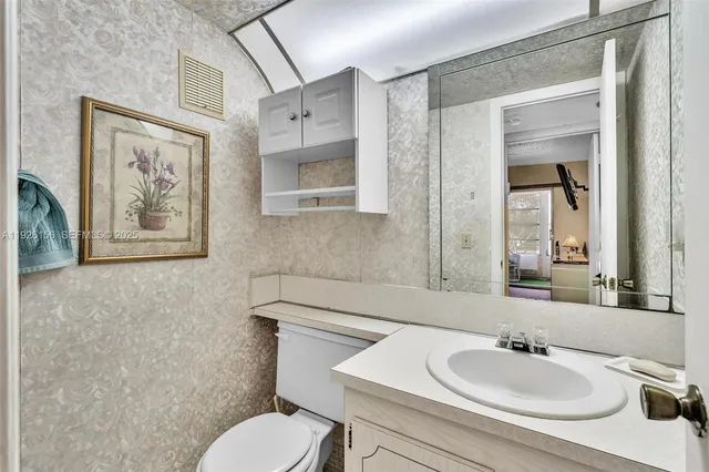 a bathroom with a toilet sink and mirror