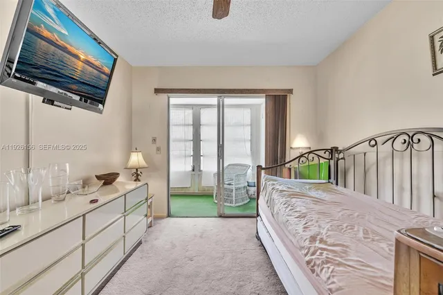 a spacious bedroom with a bed a mirror and windows