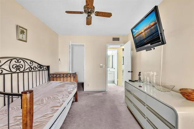 a spacious bedroom with a bed and a flat screen tv