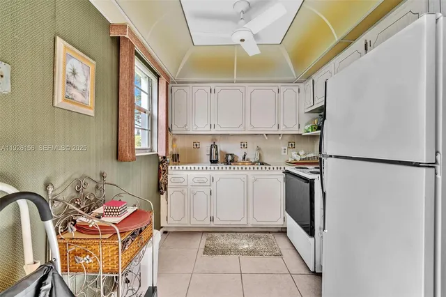 a kitchen with a refrigerator a stove a sink and a cabinets