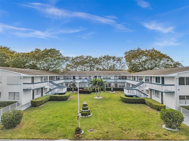 a view of a house with pool and chairs in front of house