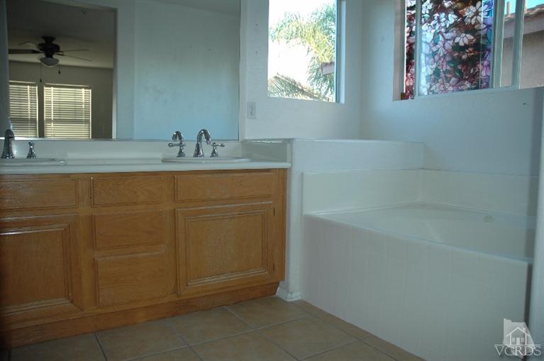 802 Pivot Point Way Oxnard, CA 93035 - Photo 10 of 13 a bathroom with a granite countertop sink a mirror and a bathtub