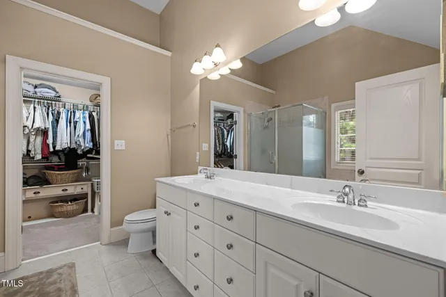 a bathroom with a double vanity sink a mirror and a shower